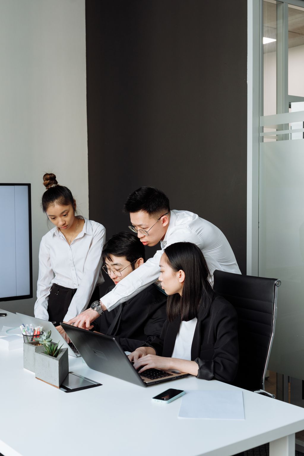 Equipo revisando una laptop durante una reunión de negocios