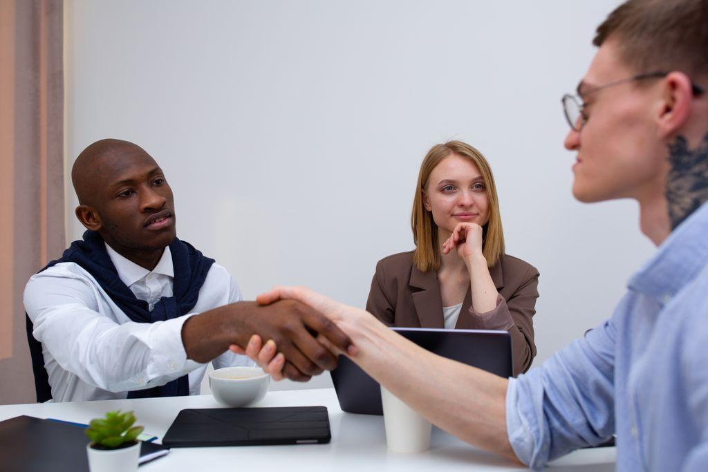 Profesionales reunidos y estrechando sus manos sobre una mesa