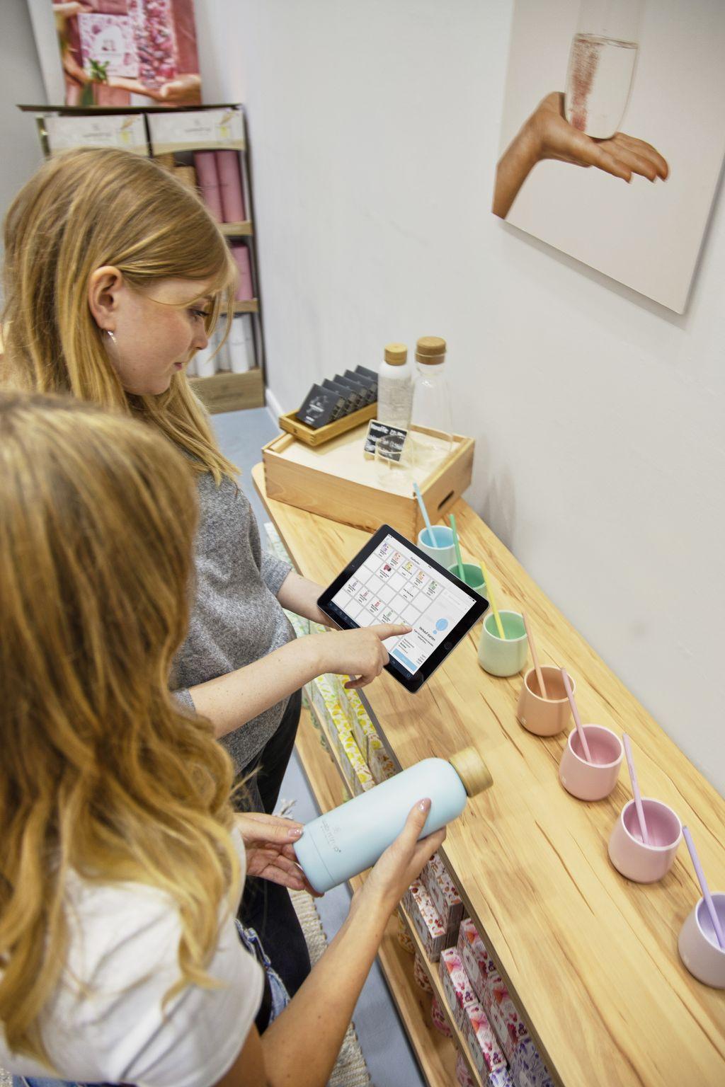 Clientes comparando productos en una tableta dentro de una tienda