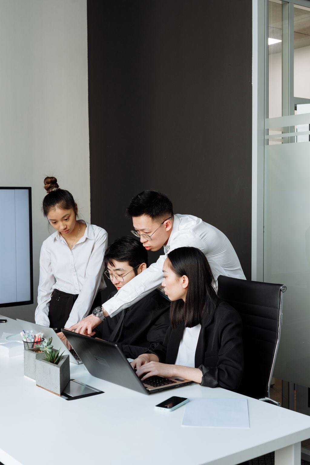 Equipo revisando una laptop durante una reunión de negocios